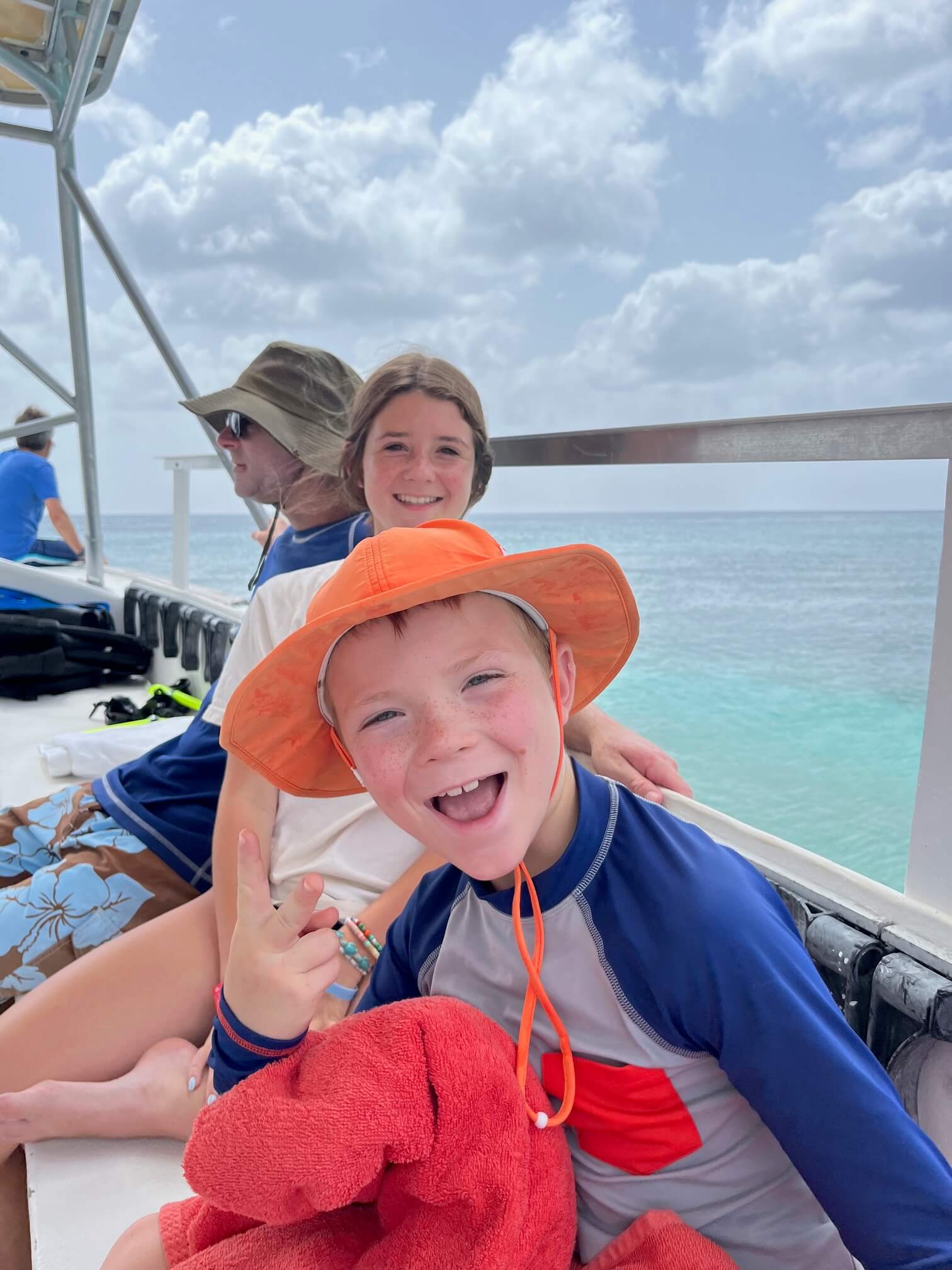 Siblings on a boat heading out to go snorkeling in Cozumel Mexico.